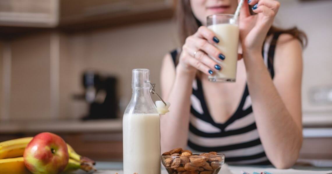 Young woman enjoying a glass of almond milk