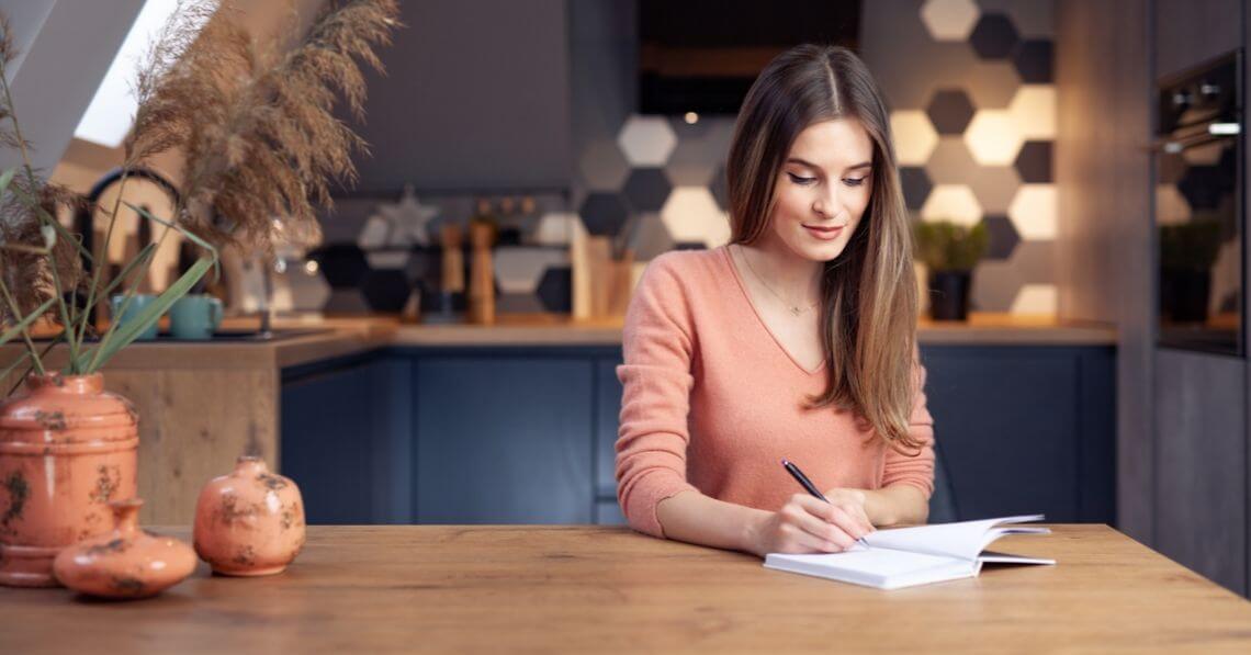 Woman writing on a gratitude journal