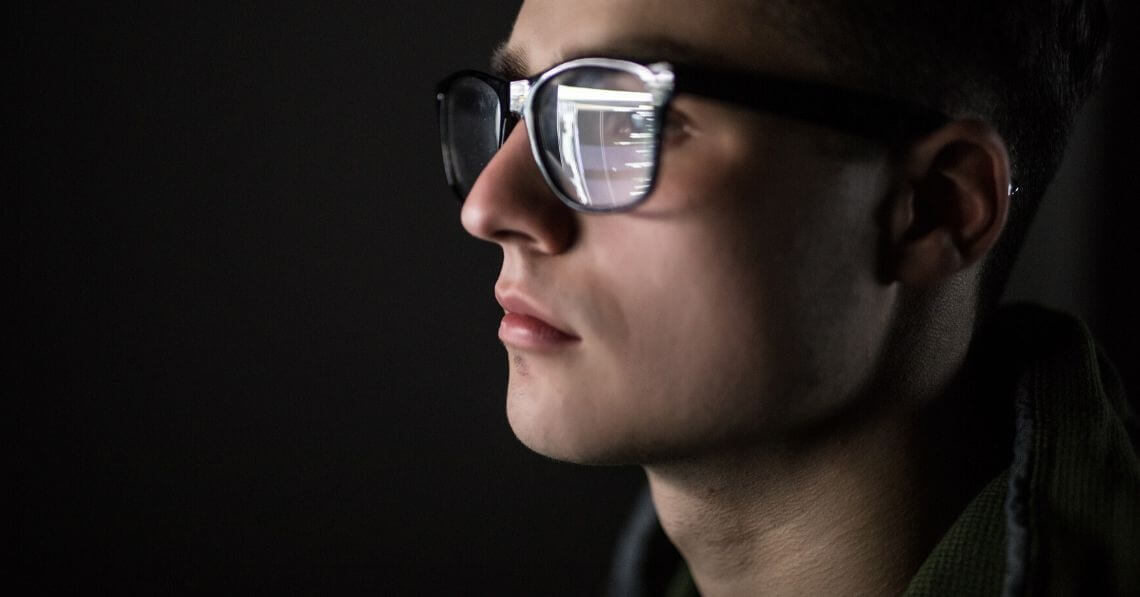 A man wearing blue light blocking glasses