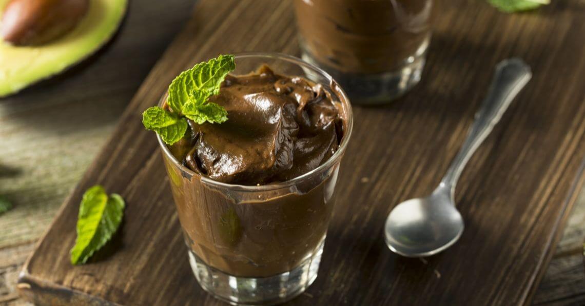 a glass of ice cream with a spoon on a wooden table