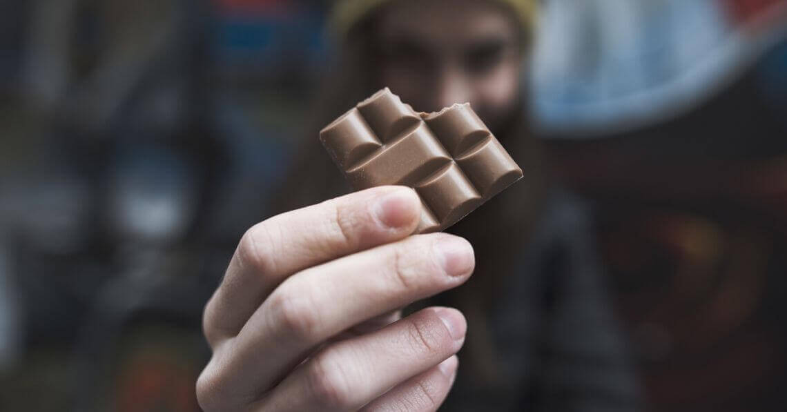 A man holding a piece of chocolate
