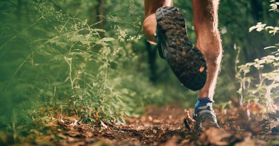 Close up of the shoes of a man running in the forest