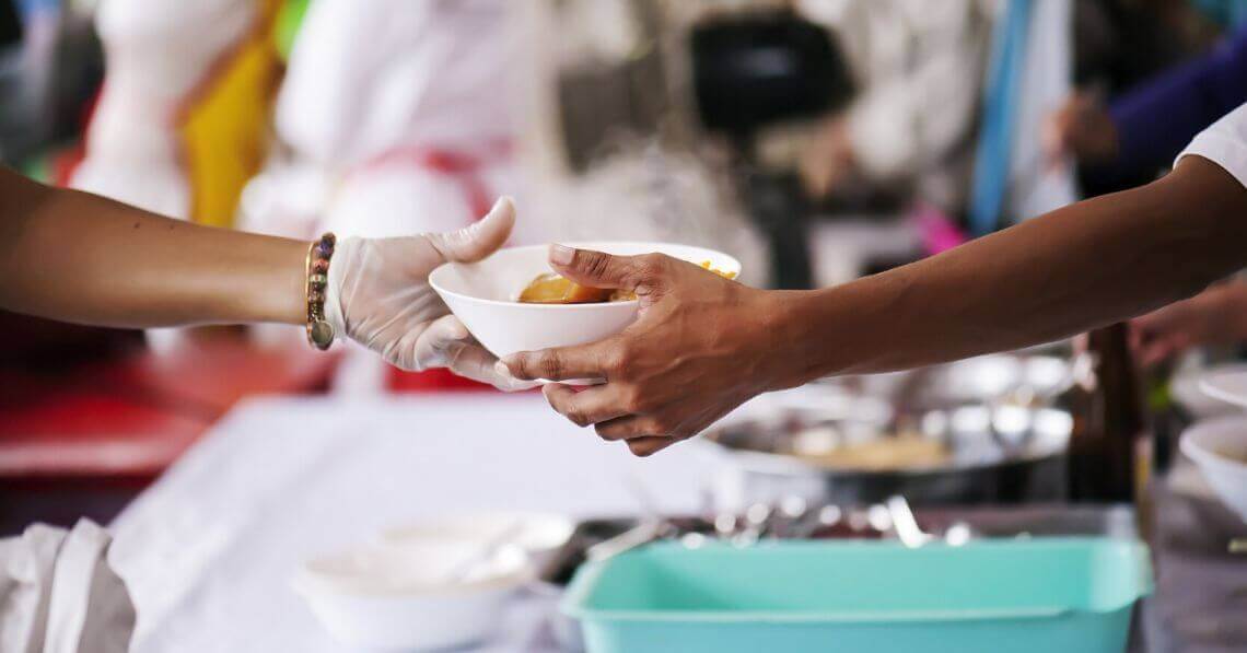 Volunteer serving food to people in need