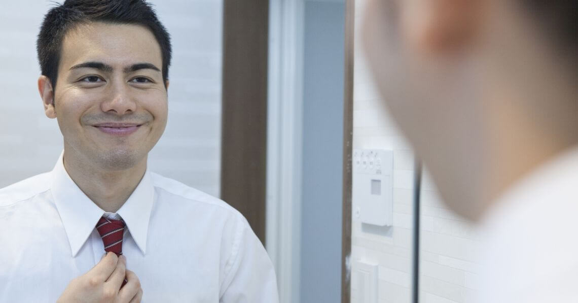 Young confident man in front of the mirror