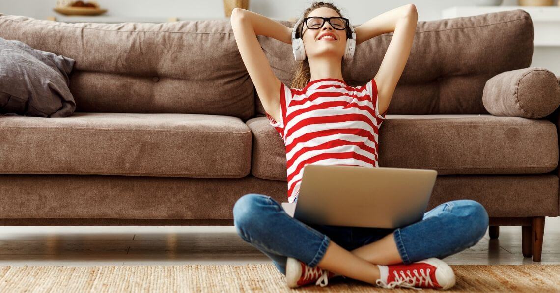 A happy woman listening to music on her computer