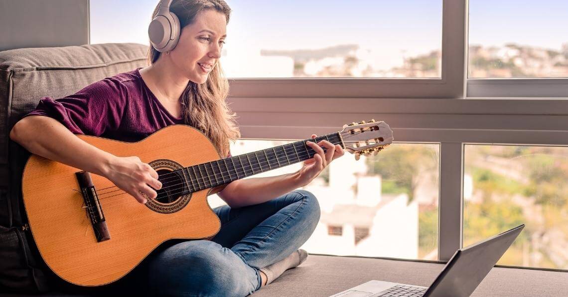 Woman learning guitar online