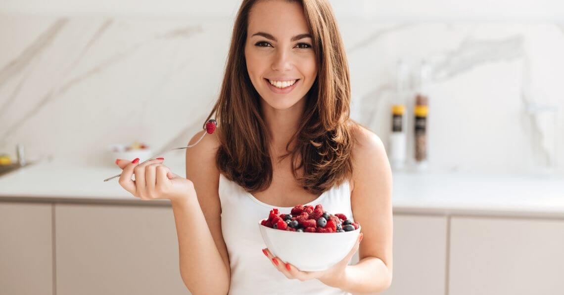 Young woman with a large bowl of berries