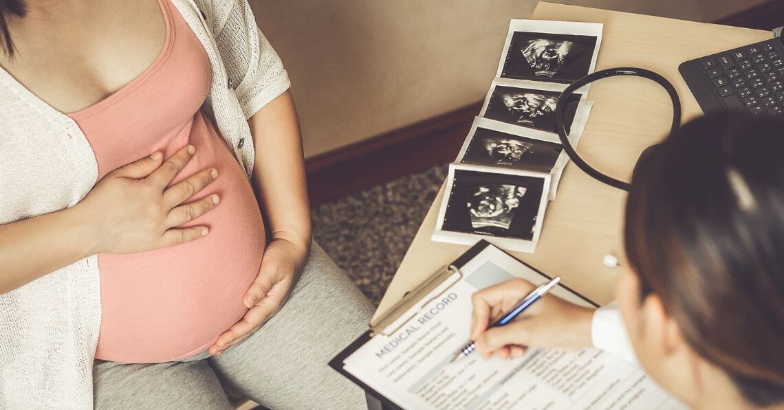 A young woman talking to her doctor about her pregnancy