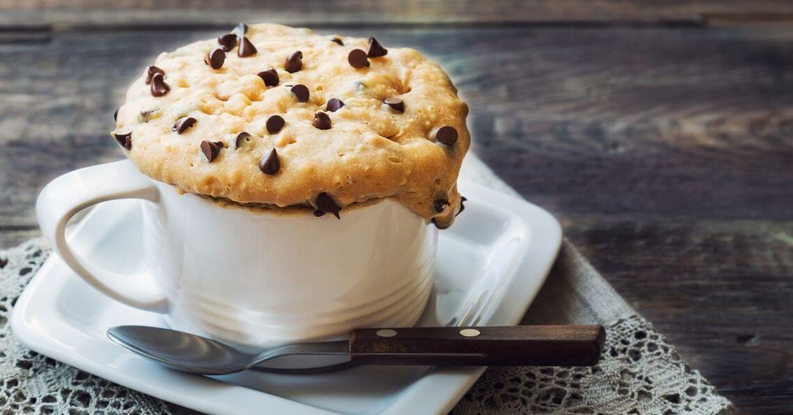 a cup of coffee with a cookie on top