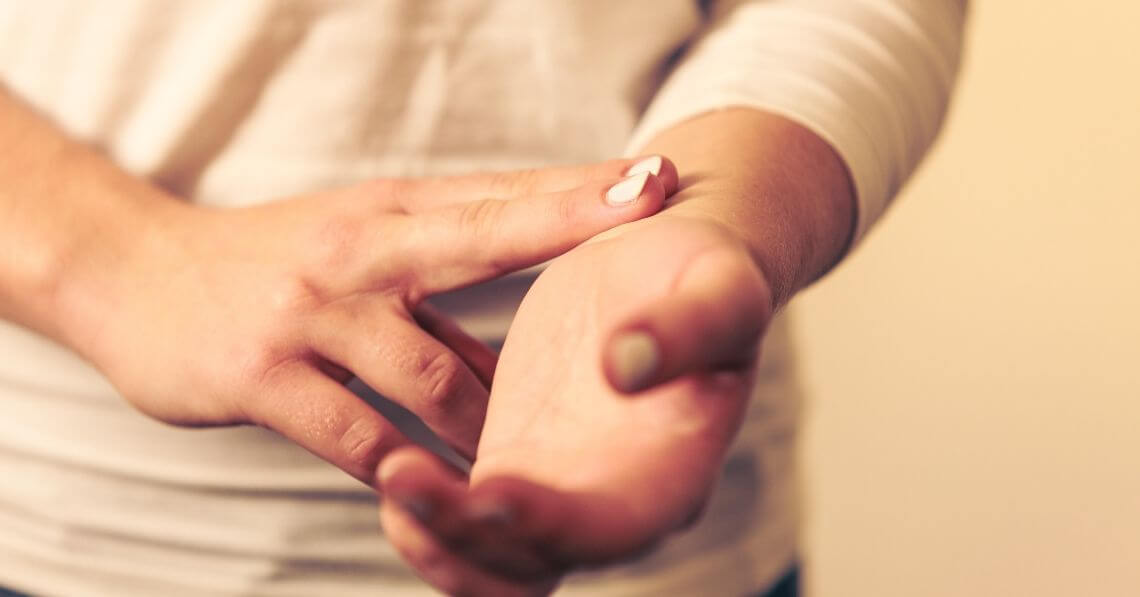 Young woman taking her own pulse