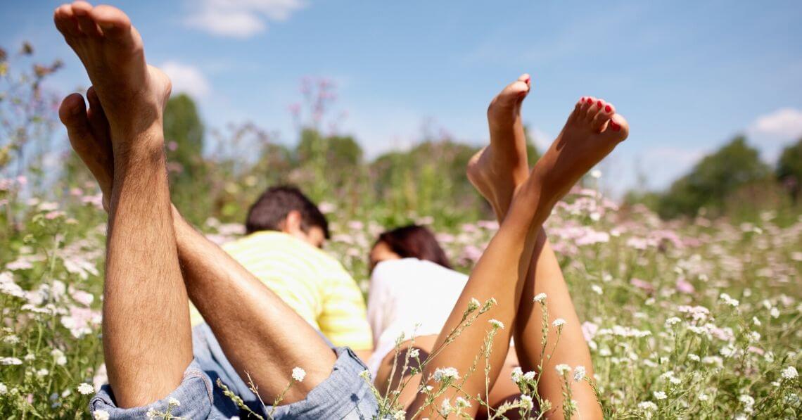 A couple laying in a field among flowers