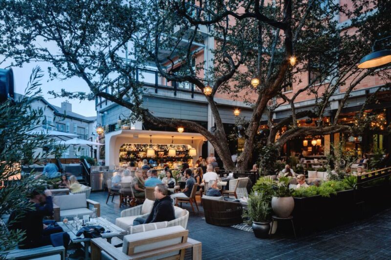 Aba Austin's patio at dusk with guests seated at the bar and various tables