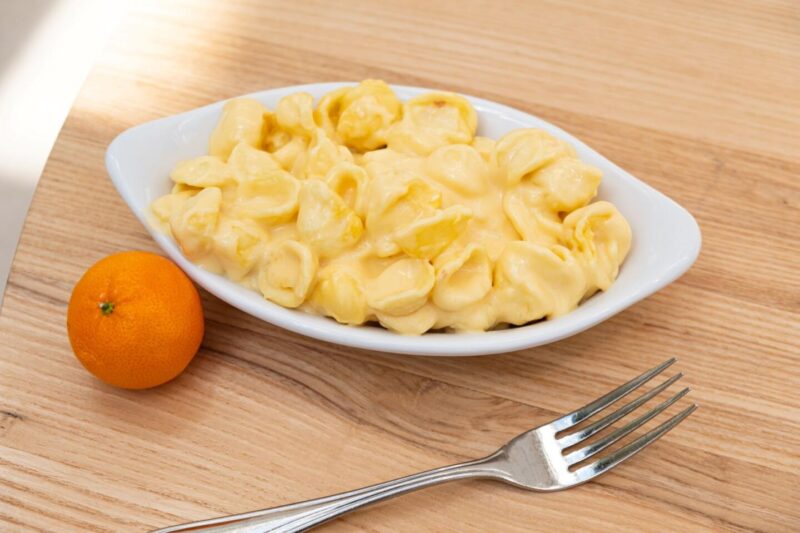 Summer House Mac and Cheese plate with a tangerine on the side