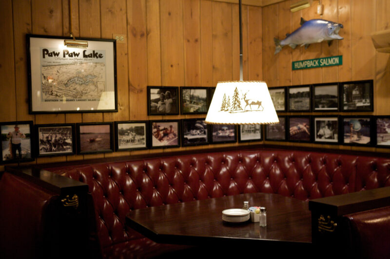 A cozy booth with rustic light fixture at L. Woods Tap & Pine Lodge