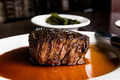 A large filet mignon sitting in au jus