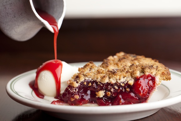 Joe's cherry pie slice with someone pouring syrup