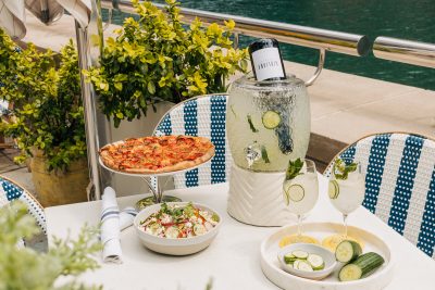 photo of an outside table with pizza, salads and the Riviera Spritz large format cocktail