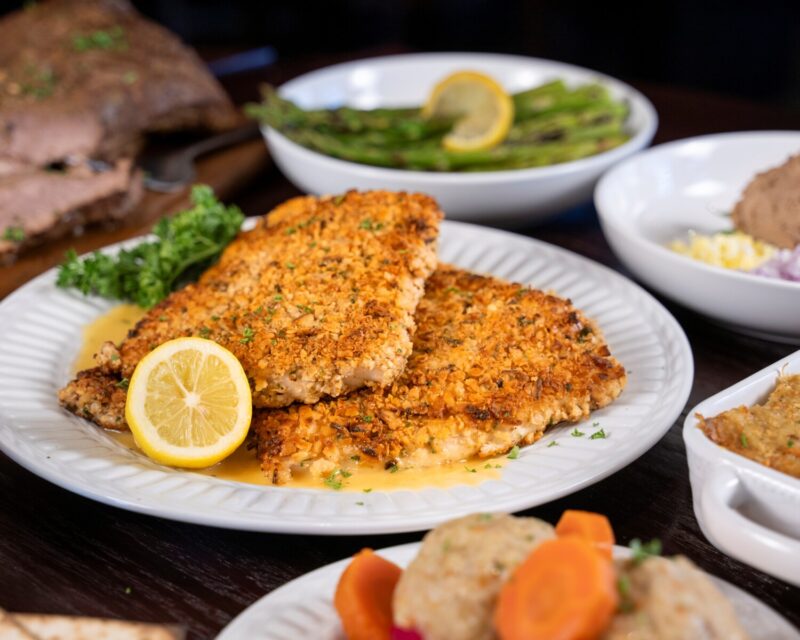 The Whitefish Passover special at Wildfire served with a lemon with other Passover dishes in background