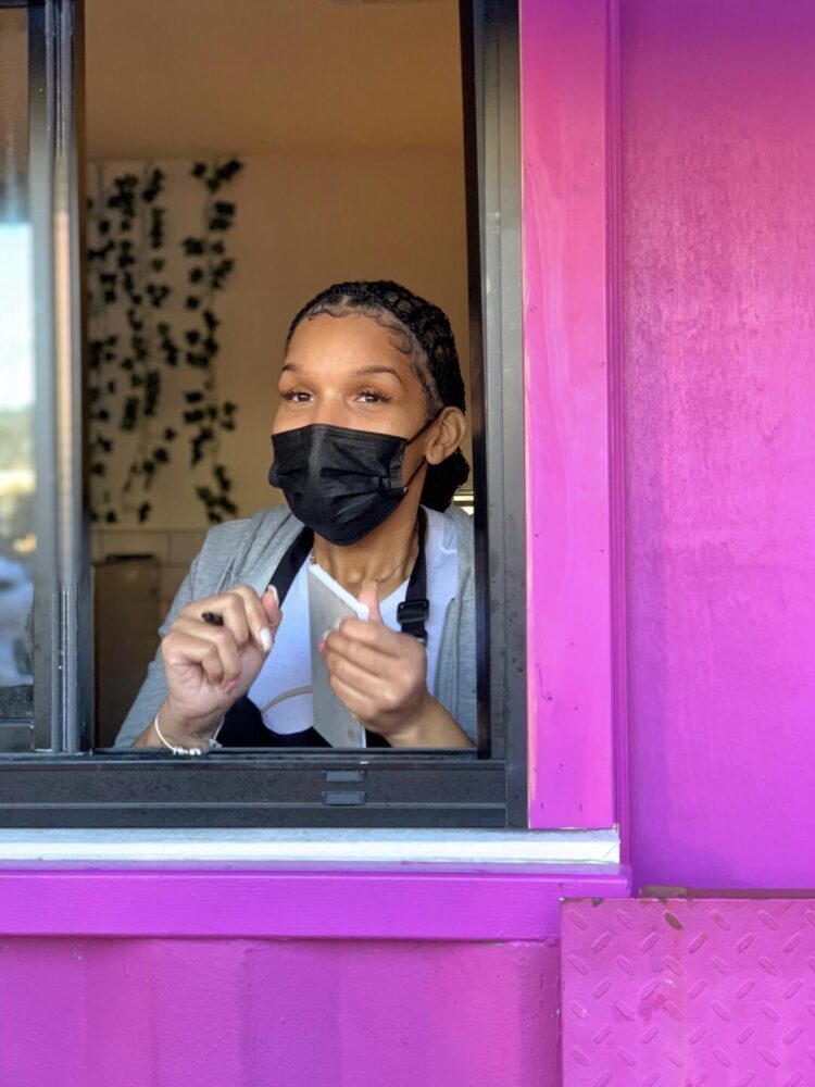 Chef Lucie standing at the window of her A.O Bistro