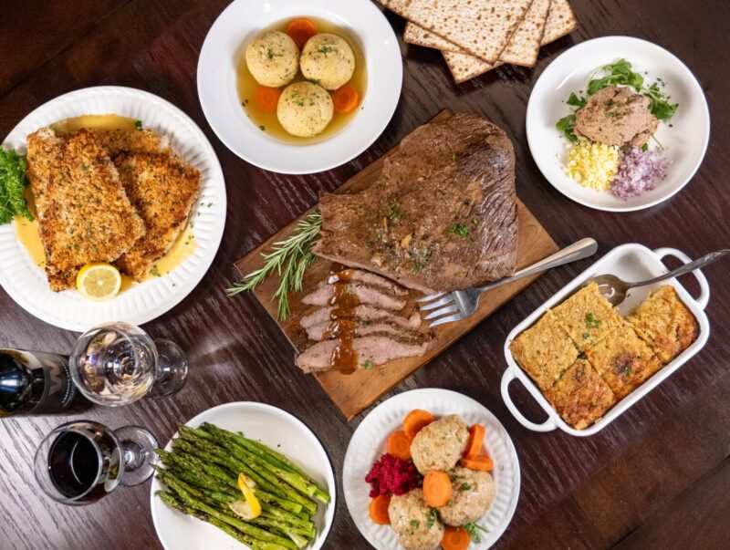 A spread of Passover dishes on a table at Wildfire along with glasses of wine
