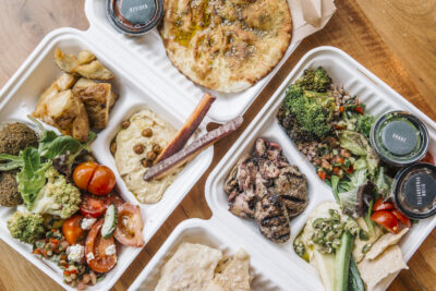 Overhead photo of a variety of food options available including pita, falafel, and hummus