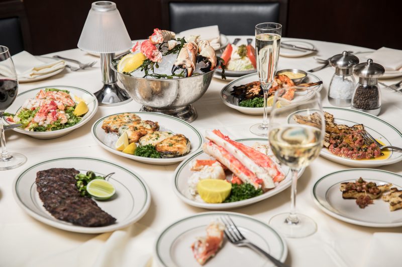 Luxurious spread of food including crab legs, steaks and lobster tails