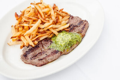 Plate of Steak Frites with herb butter at Mon Ami Gabi