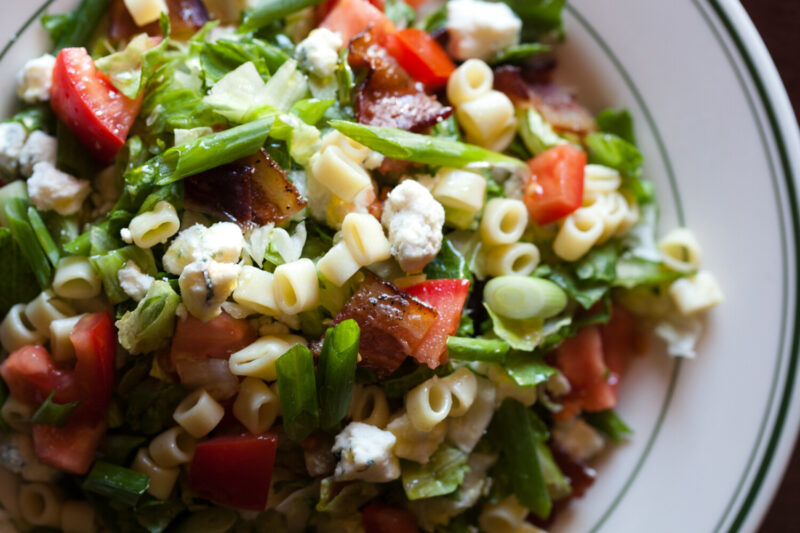 L. Woods Chopped Salad with tomatoes, blue cheese, scallions, bacon, pasta, mustard vinaigrette