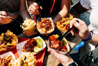 BBQ dishes and mac and cheese from windy city smokeout with people eating it