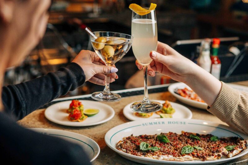 Two friends clink a dirty martini and a French 75.