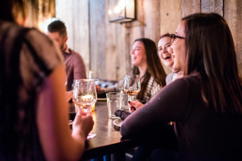 Seated crowd of people enjoying happy hour at Stella Barra