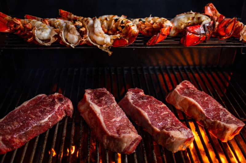 grilled steak and lobster on the grill