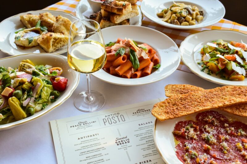 Various dishes at Antico Posto including Spicy Rigatoni Alla Vodka, white wine, salad and more