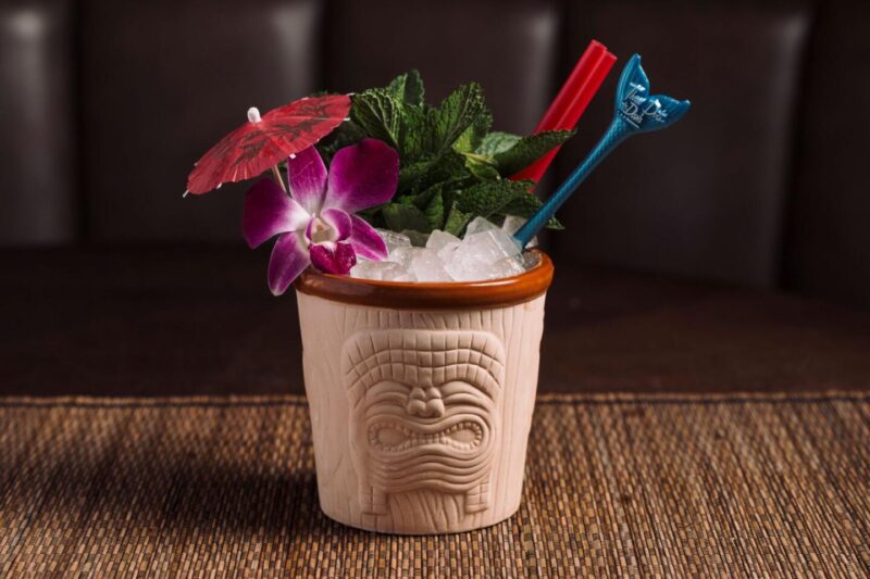 Three Dots' Mai Tai cocktail with crushed ice, mint leaves, and tiki toppers