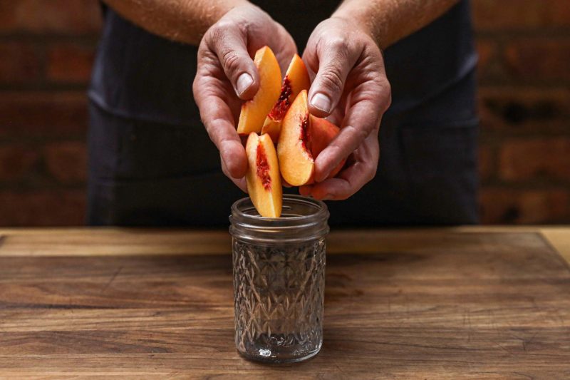 Peaches into a mason jar