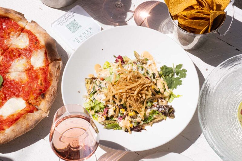 Overhead photo of the costa mesa salad next to a glass of rose wine