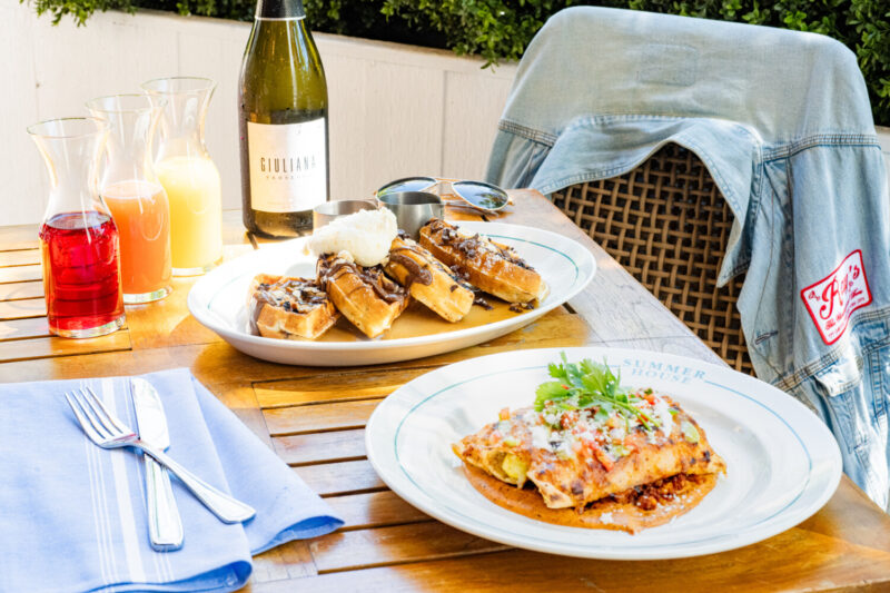 A brunch spread with prosecco, mimosas, and waffles. 