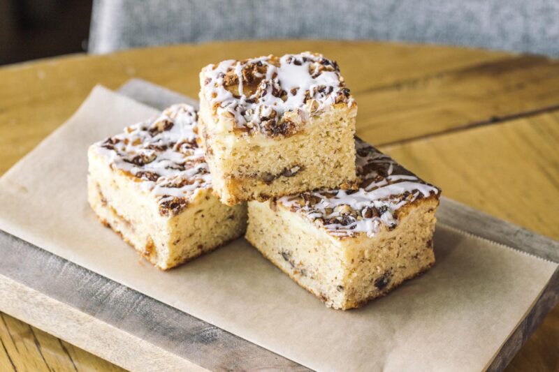 Emmy’s Gluten Free Cream Cheese Coffee Cake from Beatrix, set on a small wooden board