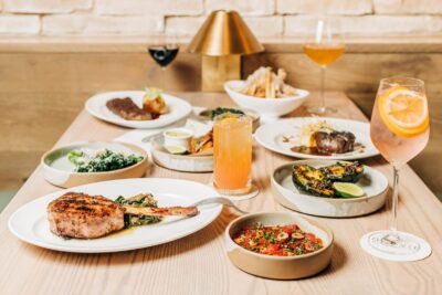 A group of dishes and cocktails in one of the booth tables