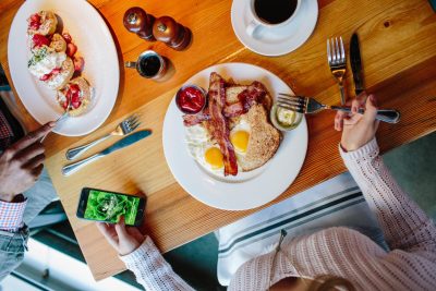 Guest dining at the table with phone for LettuceEats App