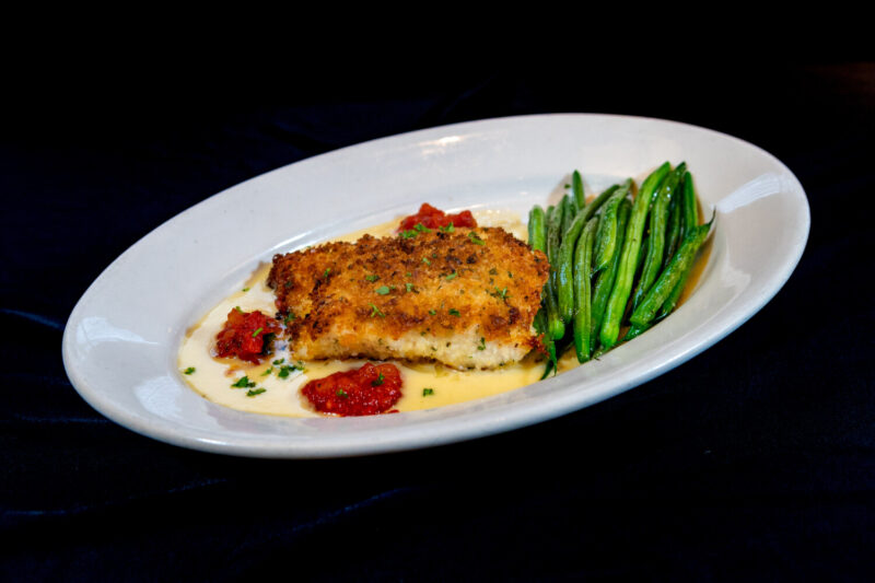 Parmesan Crusted Atlantic Cod served with roasted green beans, tomato jam, lemon butter sauce at Wildfire