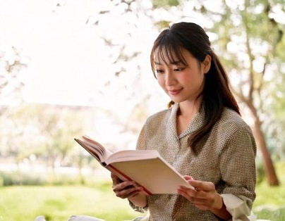 真剣に読書する女性かるく微笑む.jpg