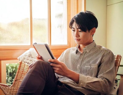 電子書籍リーダーで読書する男性　家の中 35084.jpg