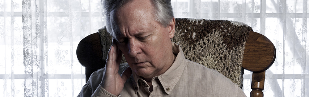 elderly man holding side of head in pain