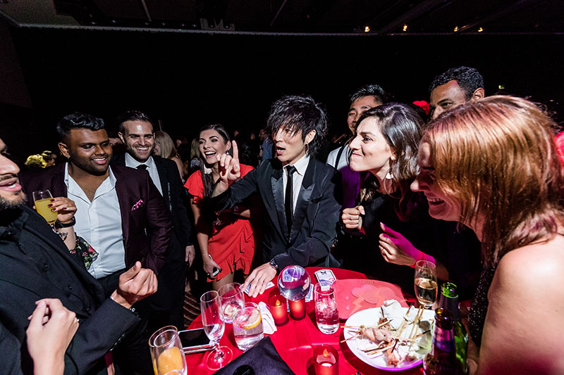 roving magician Sydney Neo performing at table with audience