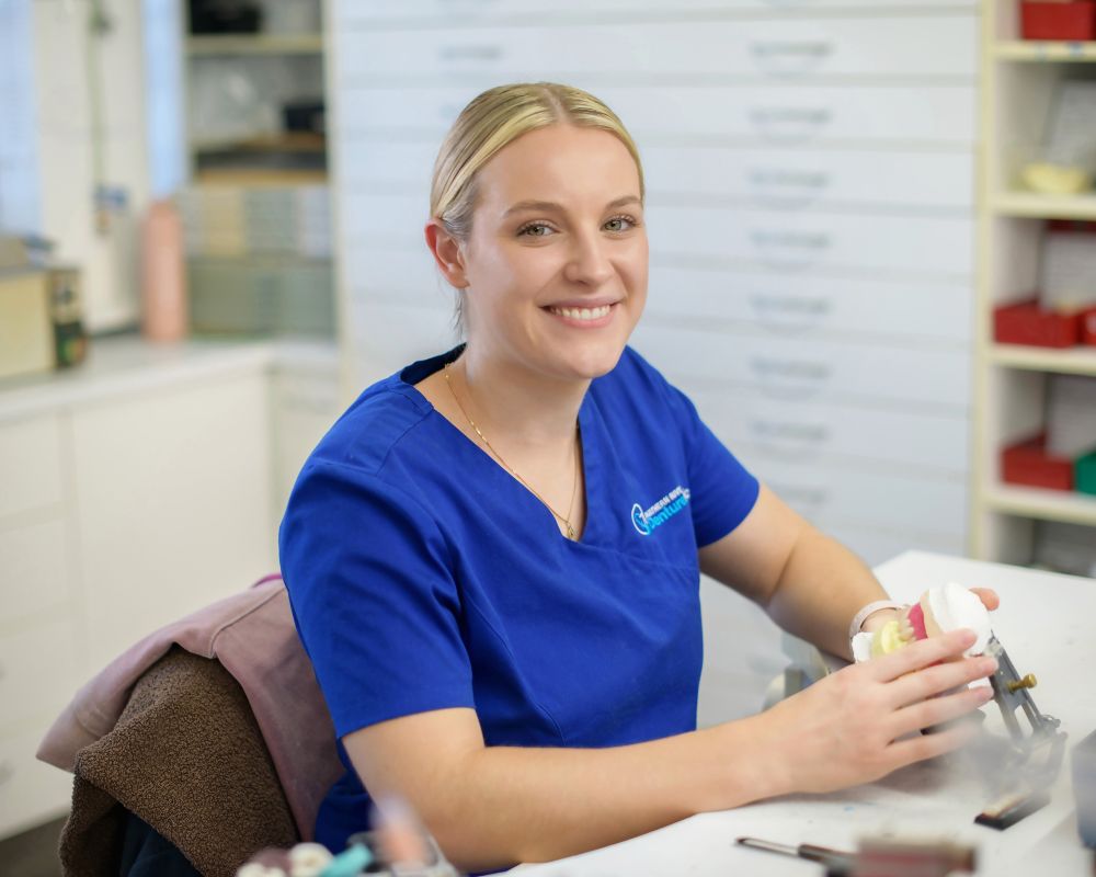 dental prosthetist reshaping denture