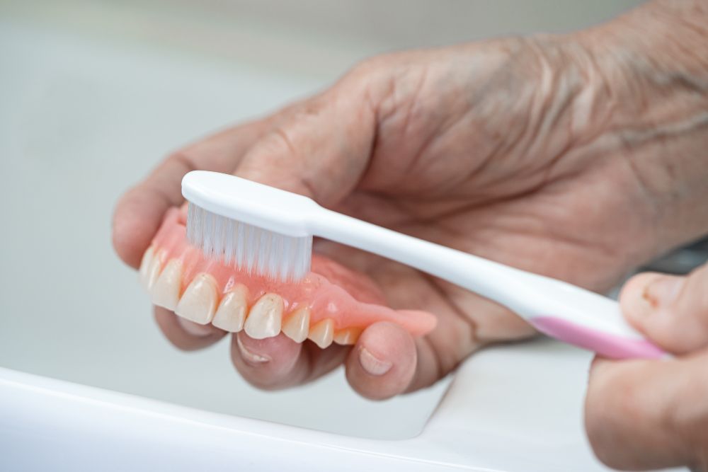 Person cleaning denture in Tweed Heads