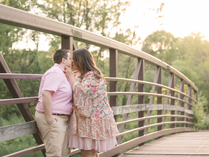 couple kissing on a bridge at Colonial Park during their engagement