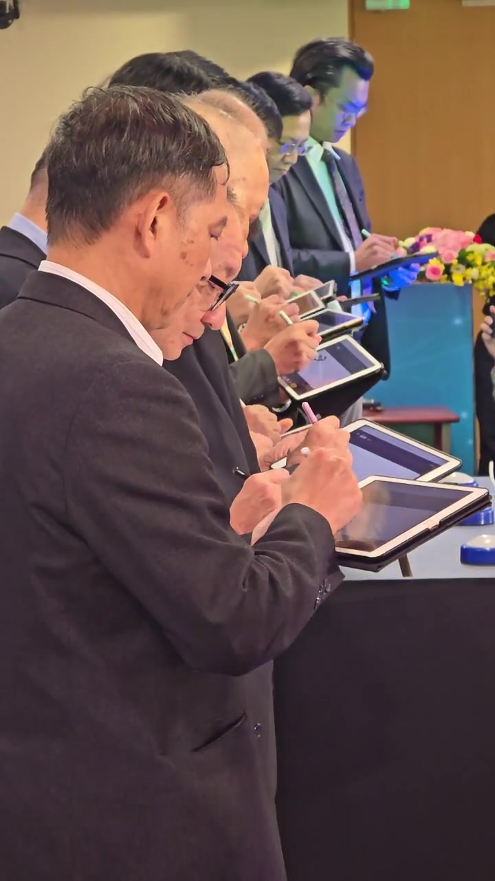 側面近拍：貴賓手持 iPad 以觸控筆簽名