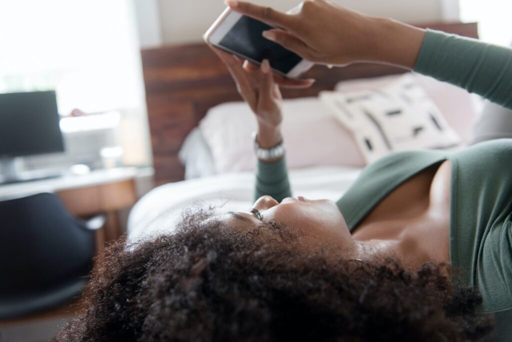 Woman on bed looking at mobile phone